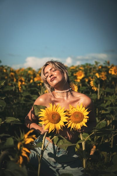 A woman in a red strapless dress with a sunflower
